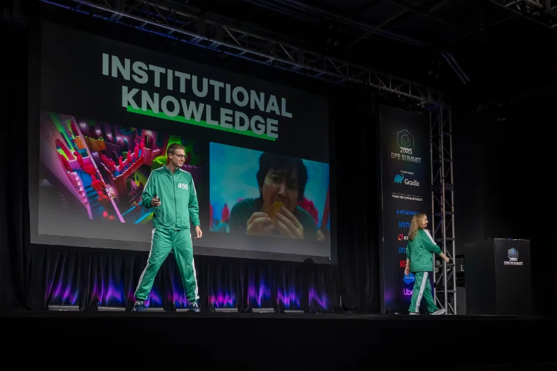 Speakers in matching tracksuits presenting "Institutional Knowledge" on stage