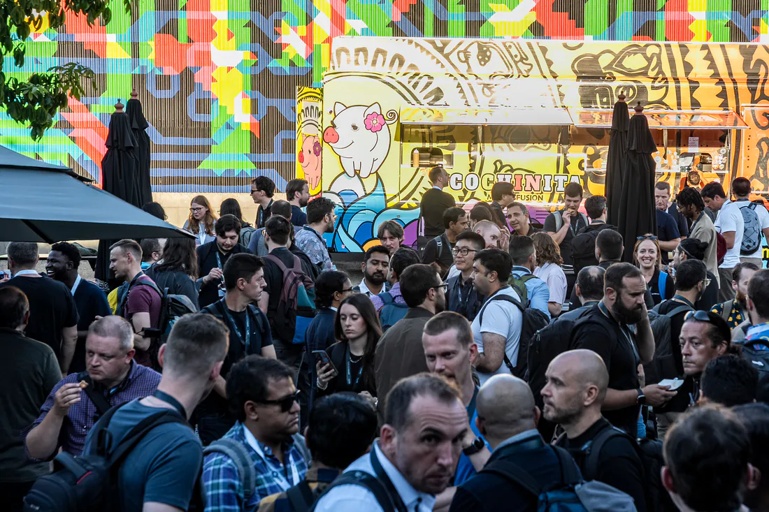 Attendees gathering by the food trucks